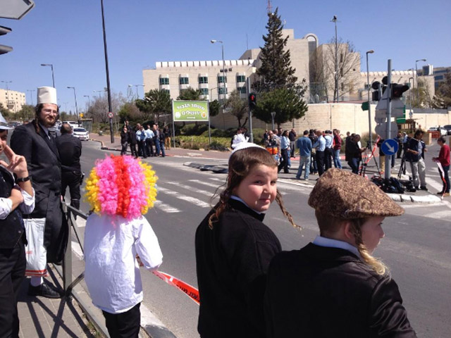 Children in costume watching the proceedings after a car ramming terrorist attack in Jerusalem, Purim 2016